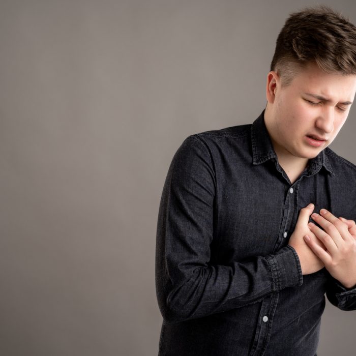 Portrait of serious stylish attractive man dressed with a casual black shirt has cardiac problem