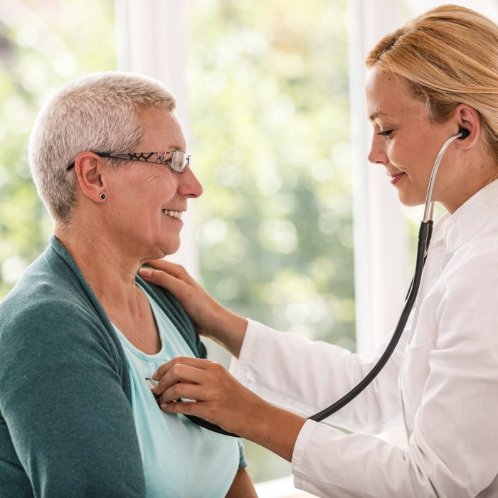 Young doctor is doing a medical examination to senior woman at the clinic.