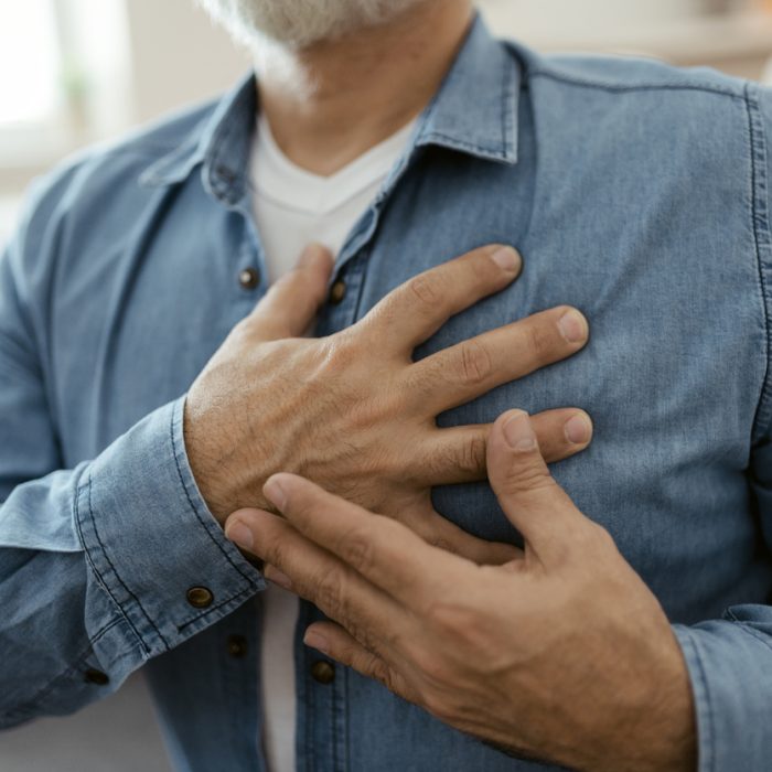 Heart attack, man with chest pain suffering at home, health problems concept