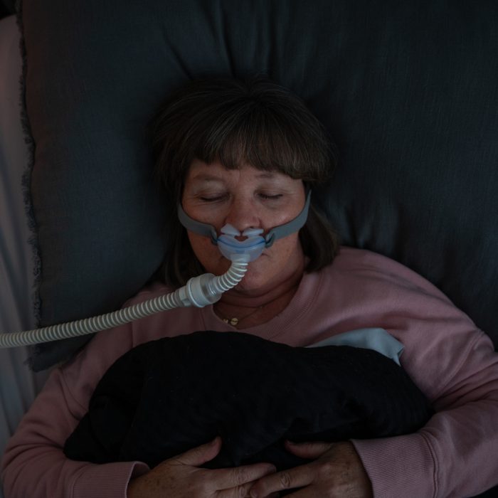Top Down Shot of A Senior Adult Woman Wearing a CPAP (Continuous positive airway pressure) Machine after being diagnosed with Sleep Apnea