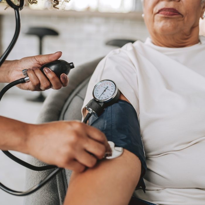 Home care healthcare worker measuring blood pressure