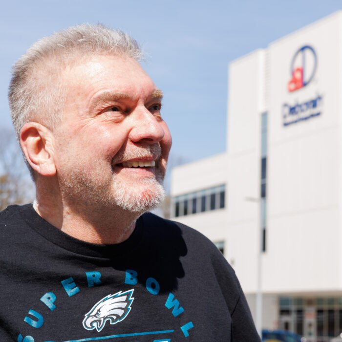 photo of man smiling in front of Deborah building
