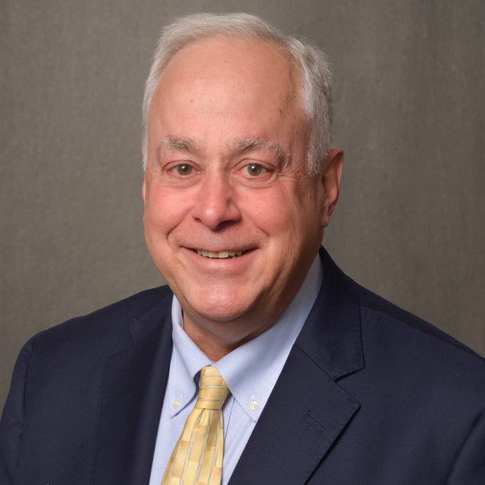 man in navy blue suit with yellow tie