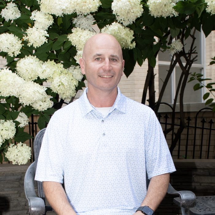 man sits in front of flowering plant