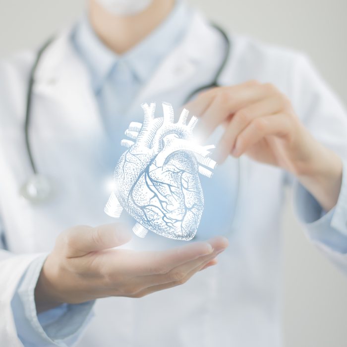 Female doctor holding virtual Heart in hand. Handrawn human organ, blurred figure, raw photo colors. Healthcare hospital service concept stock photo
