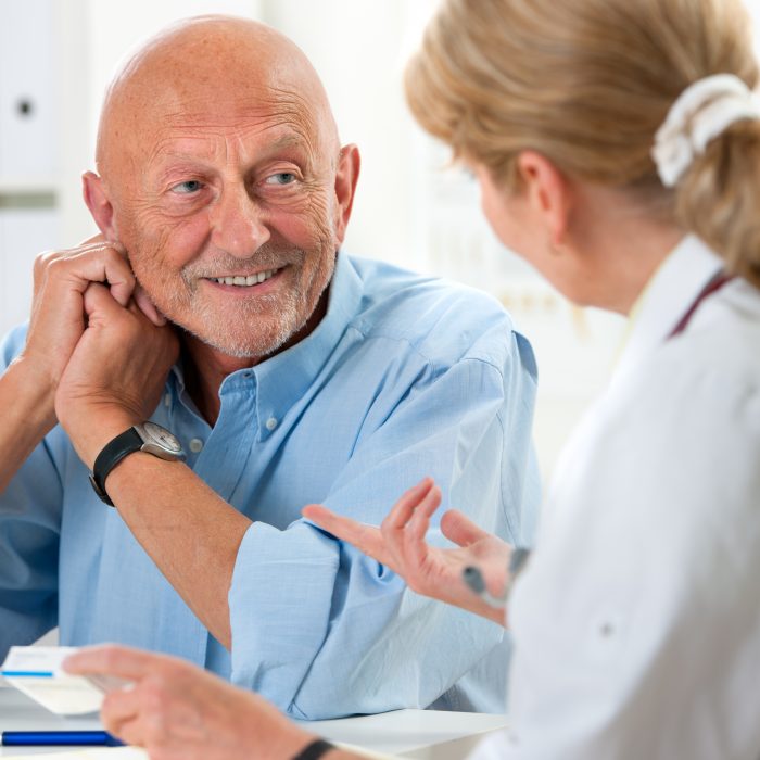 doctor talking to her male senior patient at office