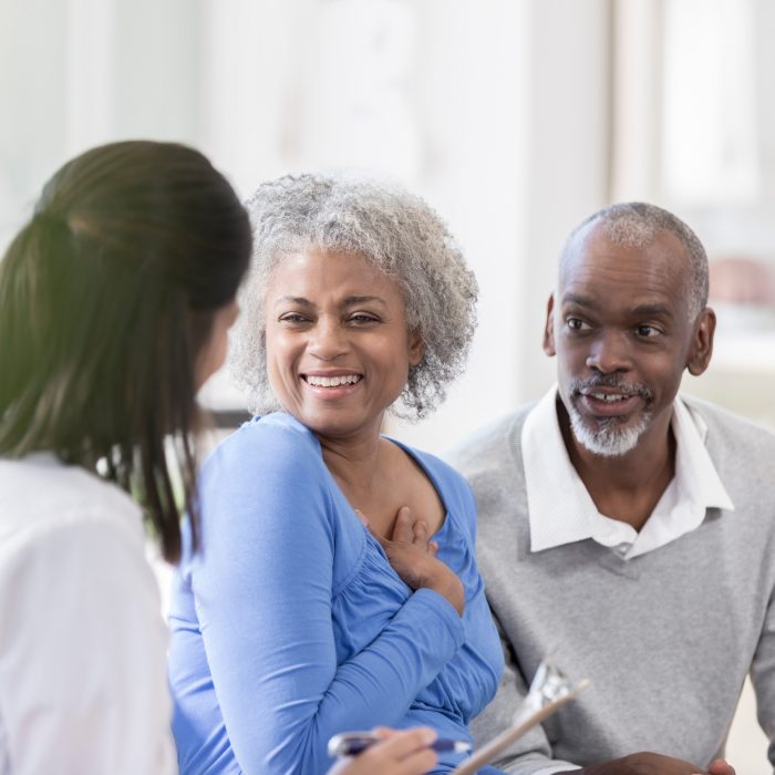 Couple speaking with female doctor