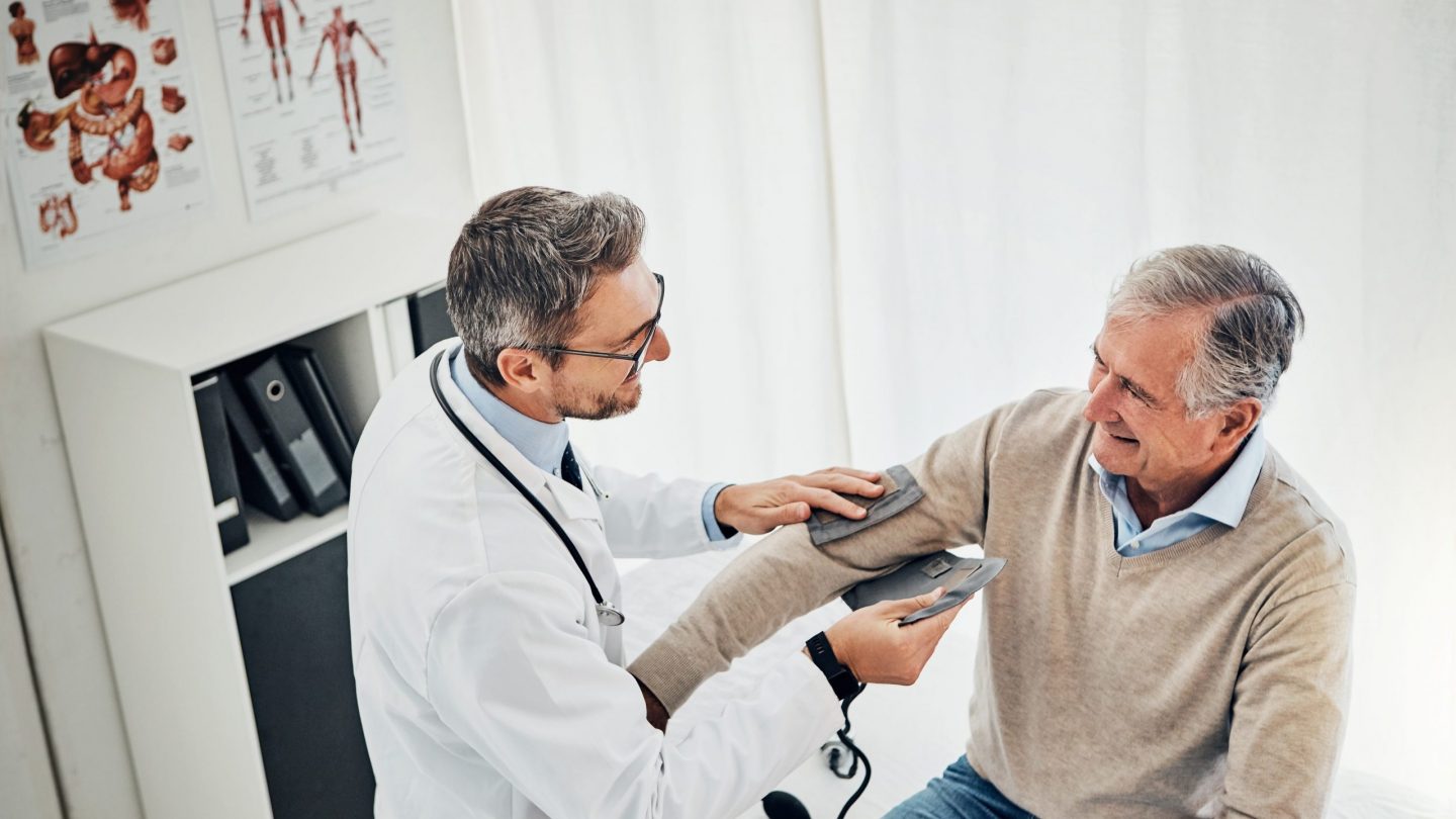 Doctor taking patient blood pressure