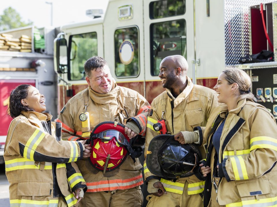 Team of firefighters standing in front of fire truck