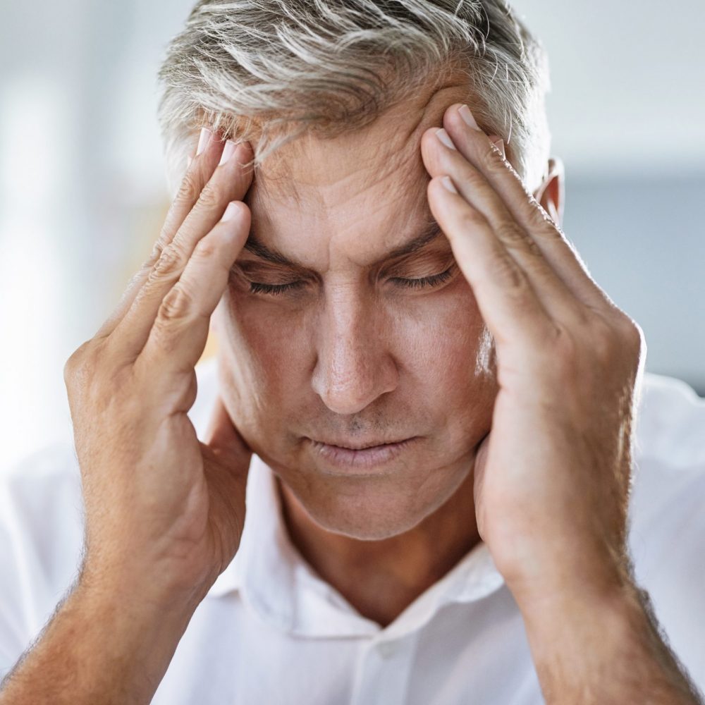 mature businessman suffering with a headache