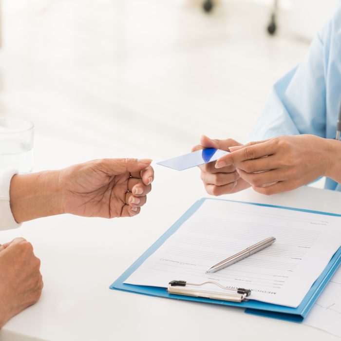 Doctor and patient having a conversation Health insurance card