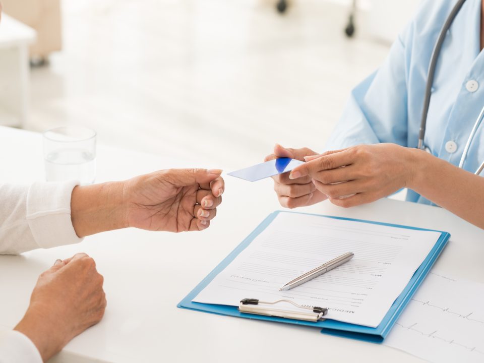 Doctor and patient having a conversation Health insurance card