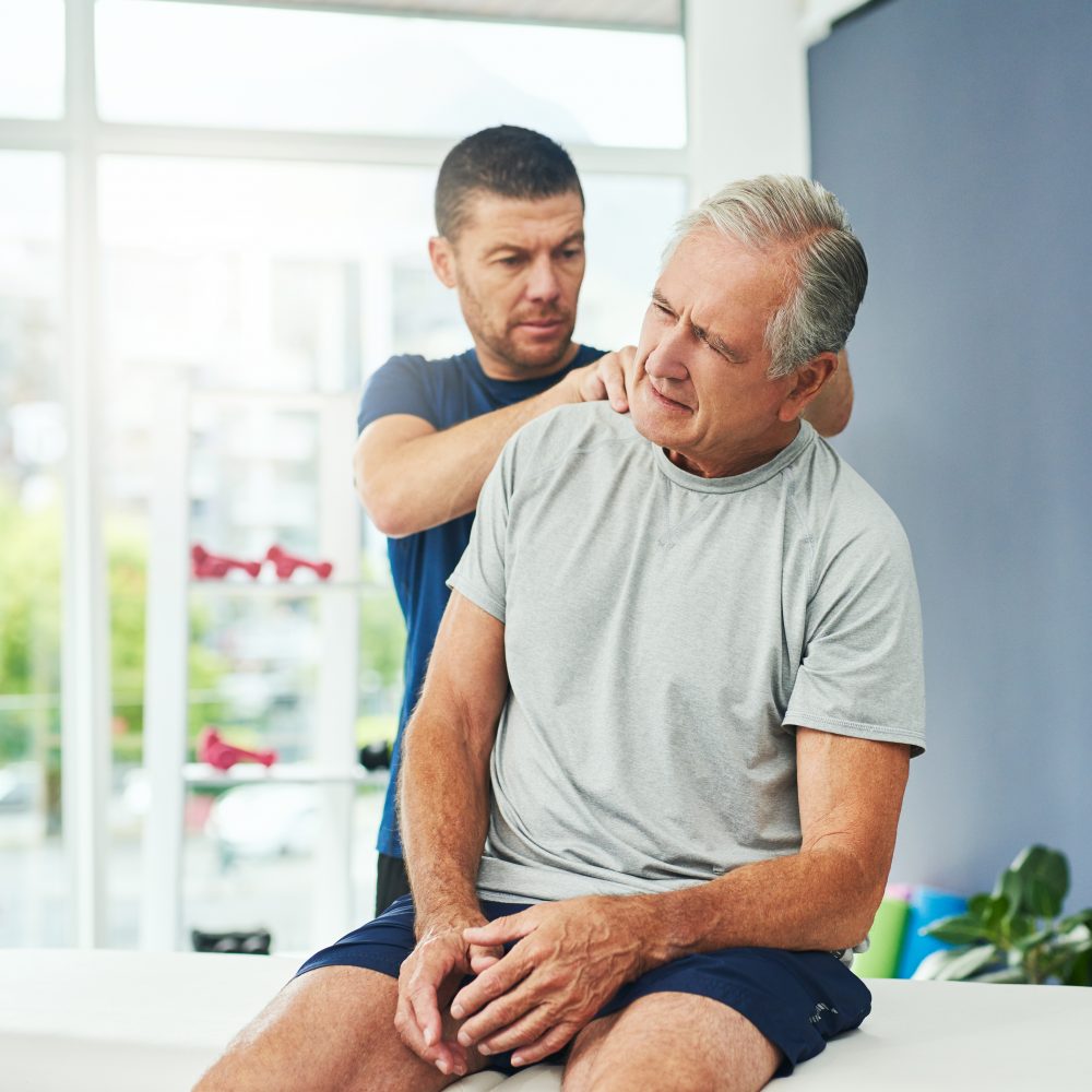  male physiotherapist doing a consultation and assessment with a senior patient