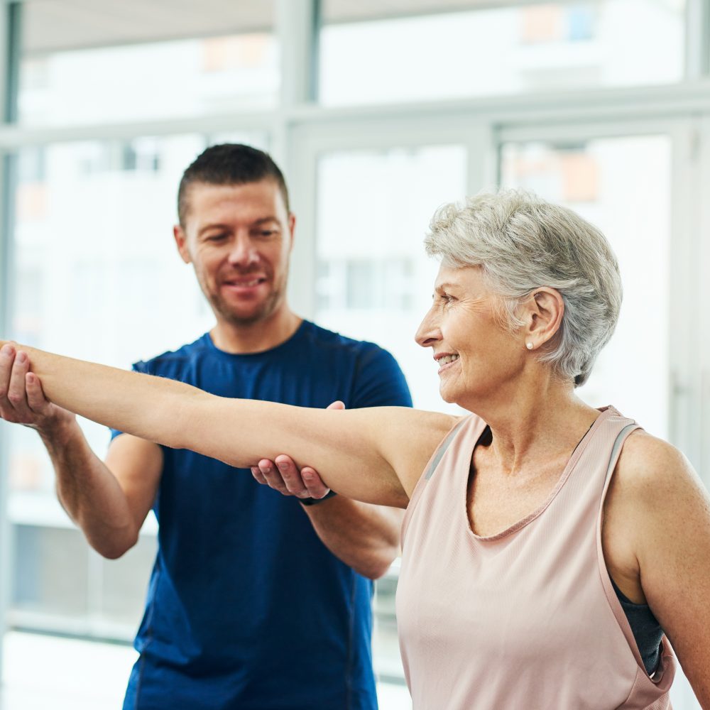 Physical therapist helping woman with arm