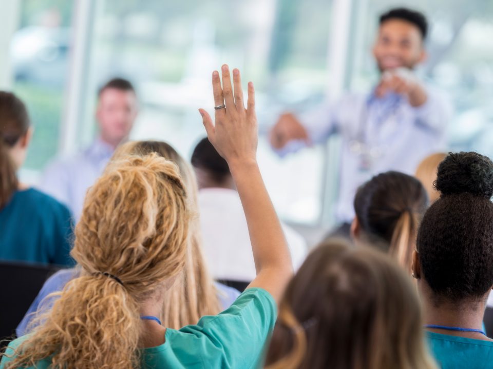 Woman asks question during healthcare seminar