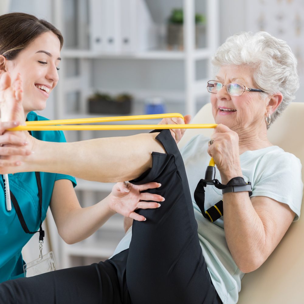 Physical therapist helps patient use resistance band