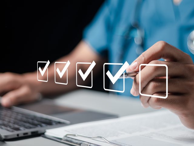 Doctor fills out the medical survey paperwork and checking mark on checkboxes.